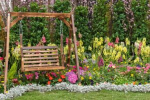 Wooden bench swing in a flower garden